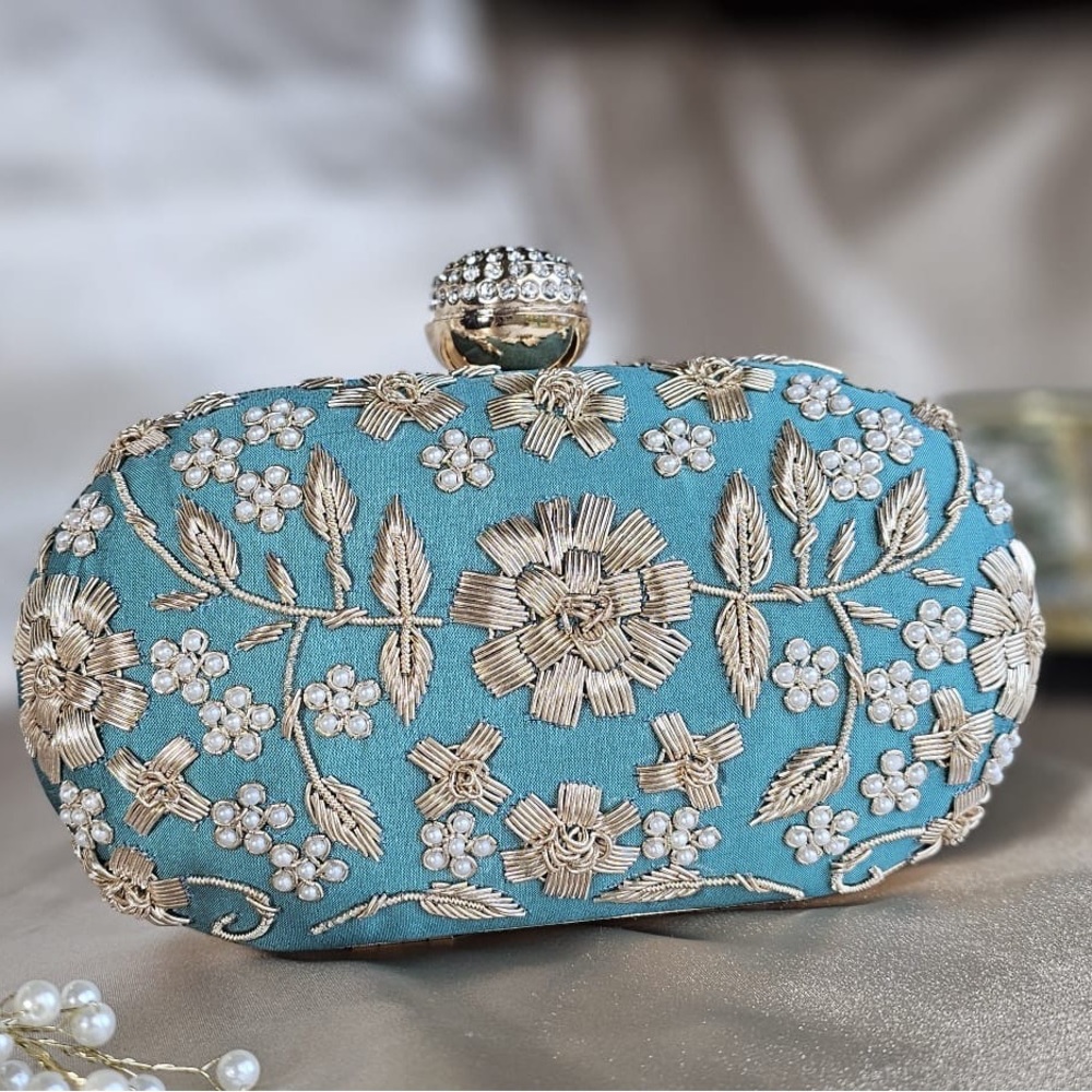 Hand embroidered oval clutch.